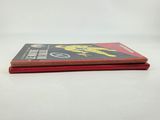 two books sitting on top of each other on a white surface
