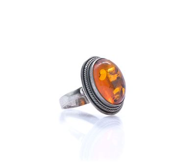 a close up of a ring with an orange stone in it