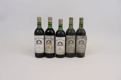 quatre bouteilles de vin sont alignées sur une surface blanche