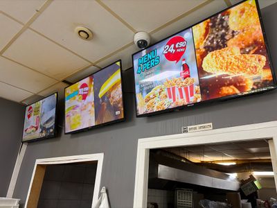 de nombreux téléviseurs accrochés au mur au-dessus du comptoir