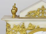 a white and gold clock sitting on top of a table