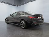 the rear end of a black bmw car in a showroom