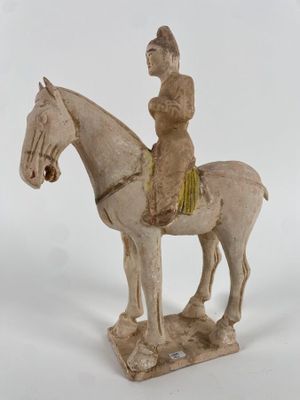 figurine représentant un homme à cheval sur fond blanc