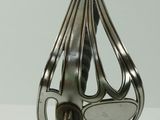 a silver spoon with a handle on a white table