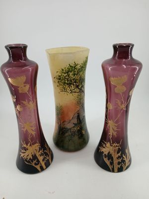 three vases are sitting on a white surface with a tree in the background