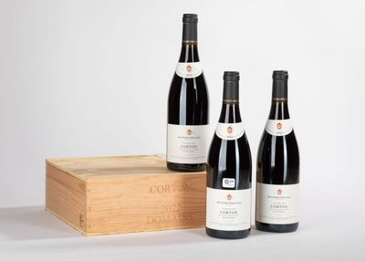 trois bouteilles de vin sont posées à côté d'une caisse en bois