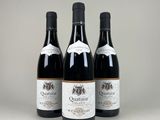 three bottles of red wine sitting on top of a table