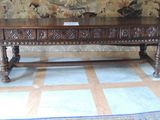 une table en bois avec un panneau devant une tapisserie