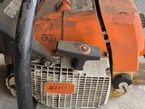 an orange and black chainsaw sitting on top of a cement floor