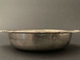 an old silver bowl with a lid on a black surface