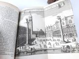an open book with a drawing of a city in it