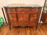 une commode au plateau en marbre dans une pièce avec du parquet