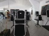 des tables et des chaises dans une pièce où se trouve un tableau noir accroché au mur
