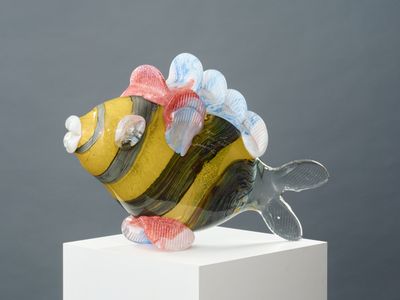a glass figurine of a fish with a bow on its head