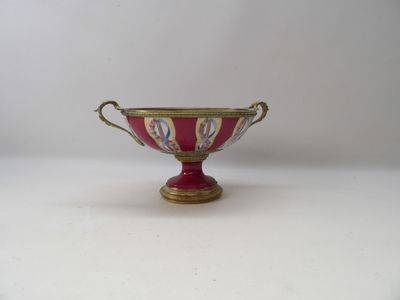 an image of a red and gold bowl on a white surface