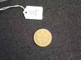 a small coin sitting on the ground next to a piece of luggage