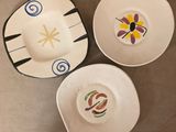 trois assiettes avec des motifs sont posées sur une table