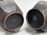 two vases sitting side by side on a white surface