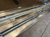 several pieces of metal sitting on top of a sidewalk next to a bench