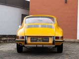 a yellow car that is parked in front of a building