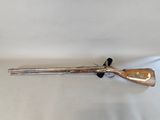 a rifle with a wooden barrel and a wooden handle