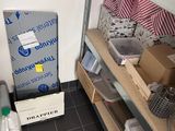 a small refrigerator in the corner of a room with a lot of boxes on the shelves