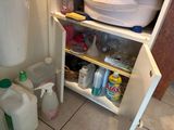 an image of a bathroom with a sink, toilet, and cleaning supplies
