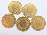 cinq pièces d'or sur lesquelles figurent les noms de différents pays