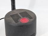 a small black object with a red button on top of it