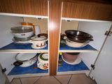 de nombreuses casseroles et poêles sur les étagères de la cuisine