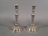 pair of silver plated candlesticks on stands on a grey background