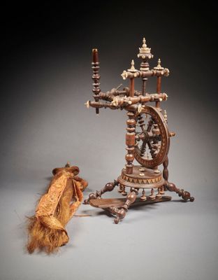 un rouet et un morceau de bois posés sur une table