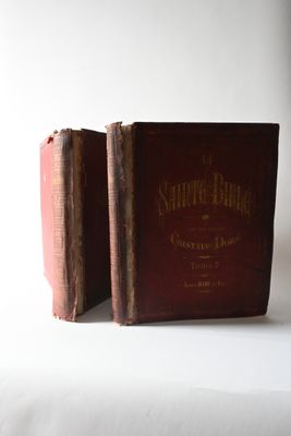 two old books sitting on a white surface