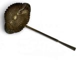 un objet métallique qui ressemble à une feuille au bout d'un bâton