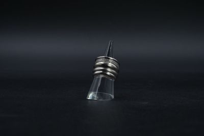 une bague en argent posée sur le goulot d'une bouteille en verre