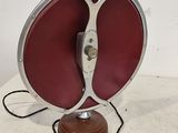 une photo d'une lampe de table rouge et argentée posée sur une surface blanche