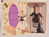 une poupée dans une boîte sur laquelle figure l'image d'une femme en robe tenant un éventail