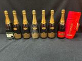 six bouteilles de champagne sont alignées à côté d'un sac rouge