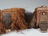 paire de masques africains aux cheveux longs sur fond gris