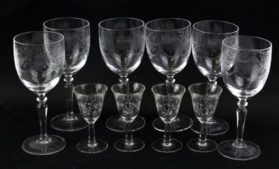 six empty wine glasses sitting next to each other on a black surface