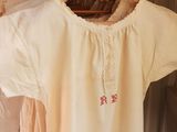 a white shirt hanging on a clothes rack in a room