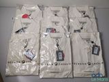 Six t-shirts blancs sont emballés dans des sacs en plastique sur une table