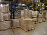 boxes are stacked on pallets in a large warehouse area