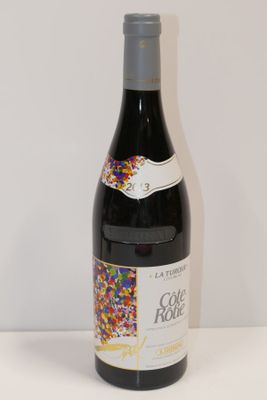 La bouteille de vin, posée sur la table, est parsemée de paillettes.