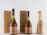 three bottles of wine sitting next to a bottle of wine on a table