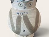 un vase blanc orné d'un motif représentant un hibou