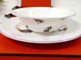 a bowl and saucer on a table with a red box