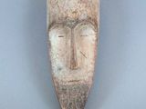 gros plan d'un masque en bois sur une surface grise