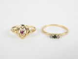 two gold rings, one with a heart and the other with a ruby stone