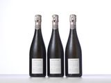 three bottles of champagne sitting on top of a table